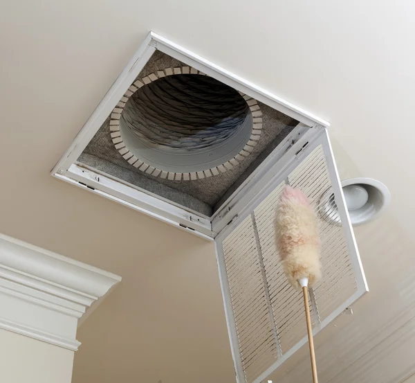 Technician performing air duct cleaning